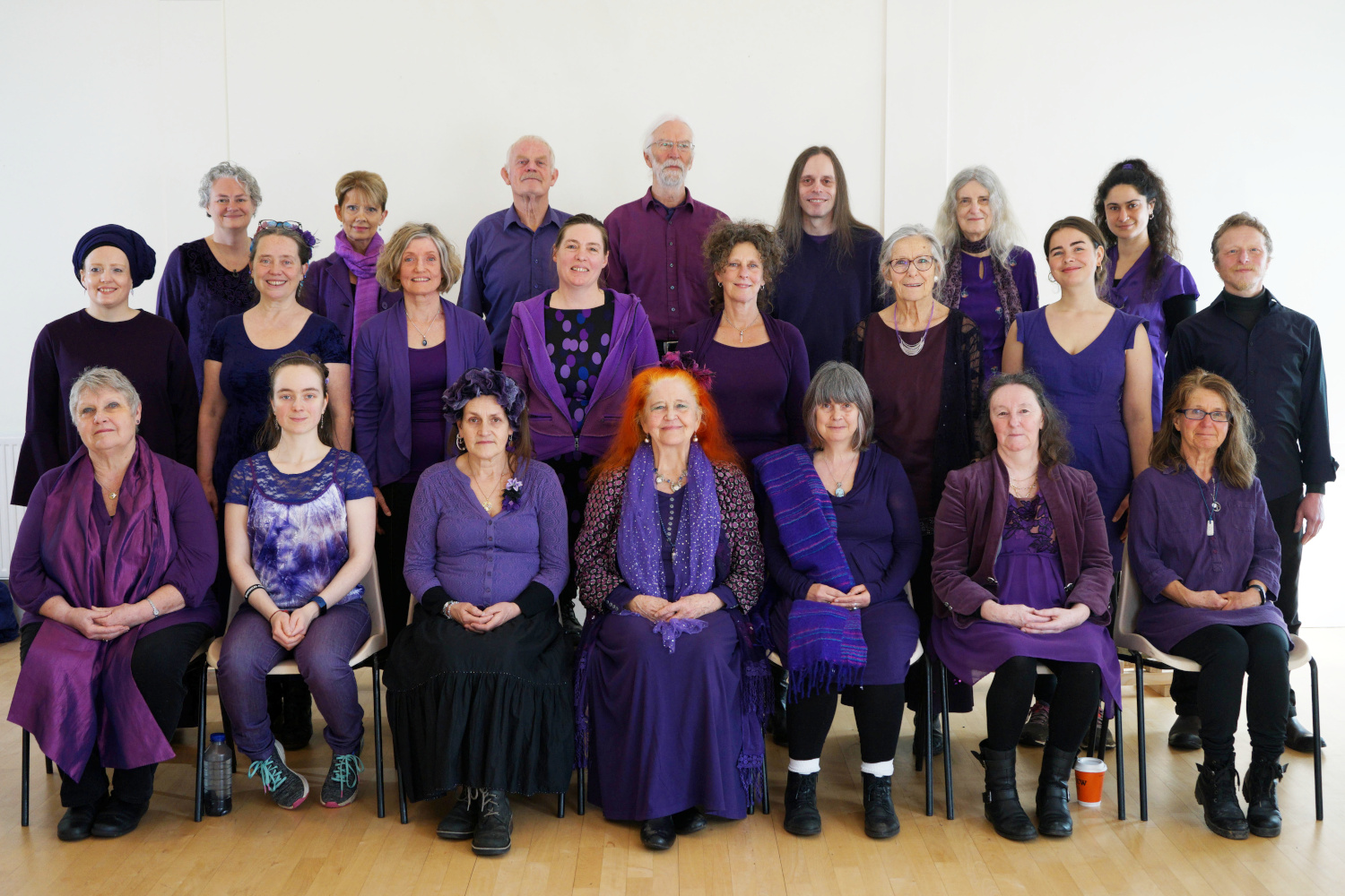 Three rows of people dressed in purple.