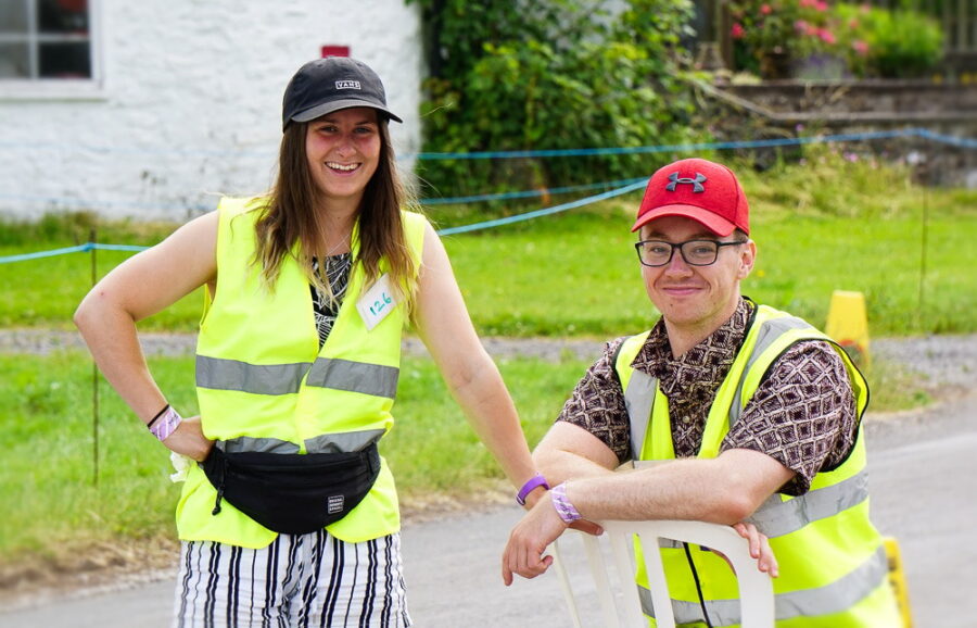 Two people in yellow vests smiling.