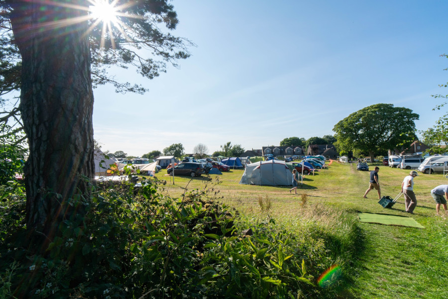 Tents in a field in the sun.