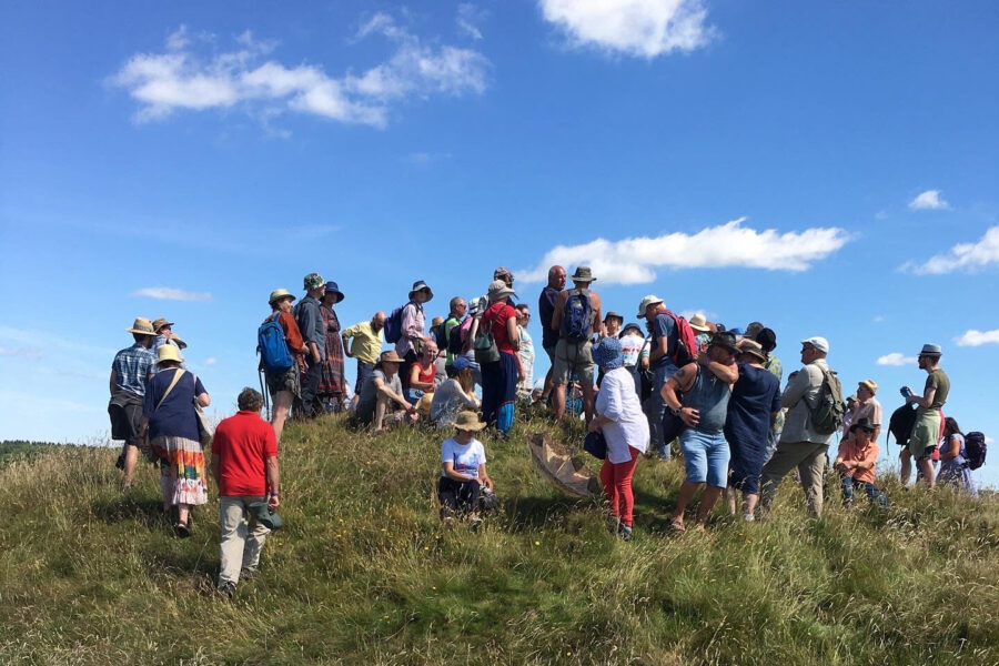 A group of people walking up to the top of a hill.